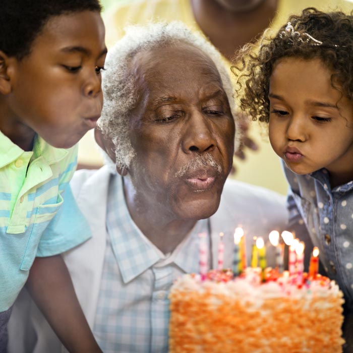 Grandfather blowing out birthday candles
