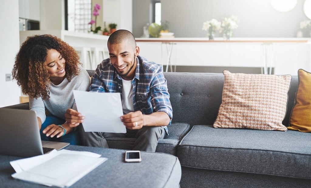 couple sitting on the couch learning about interest rates.