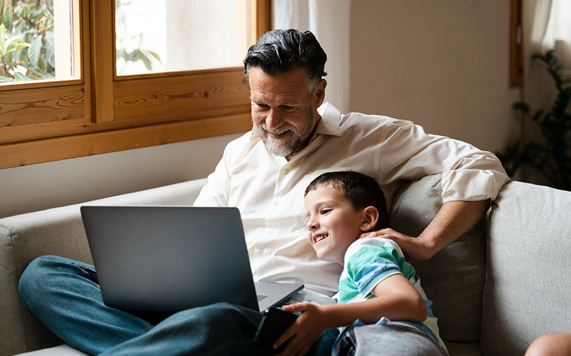 Father and son on couch looking at laptop