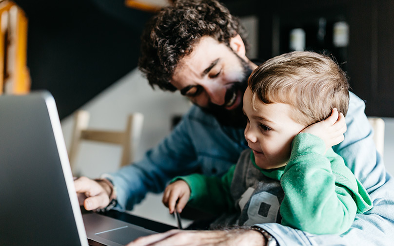 Father learning about personal loans with baby next to him