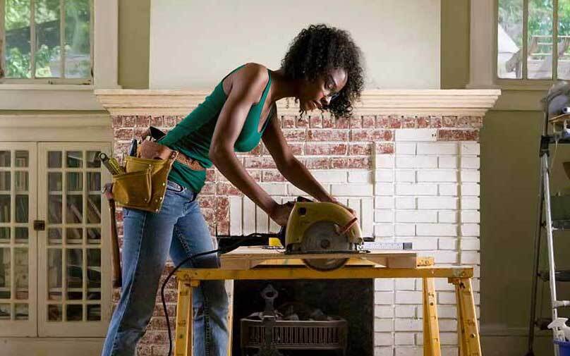 Woman with circular saw working on home