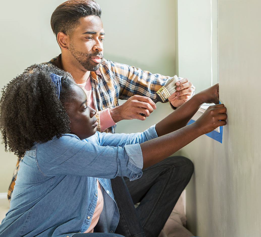 man and woman painting a wall