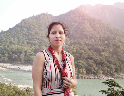 Woman posing for a picture in a mountainous landscape