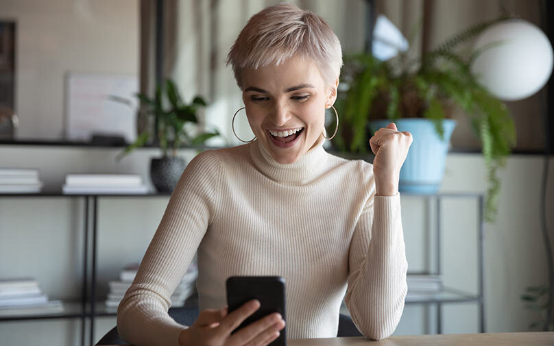 Woman excited looking at her phone