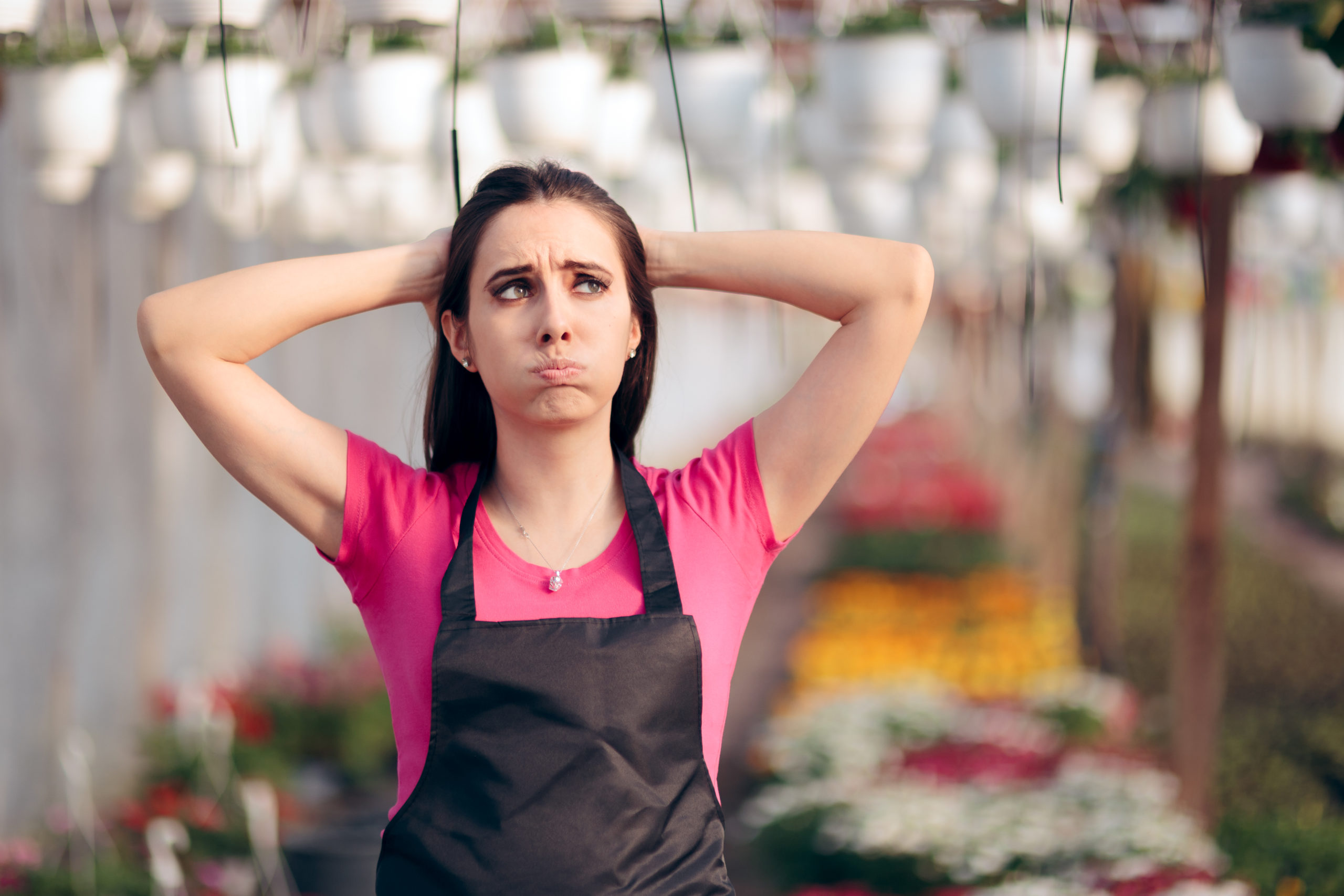 Woman in a garden house with a stressed look on her face