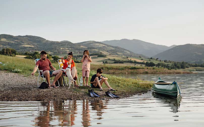 Family sitting at the lake enjoying vacation