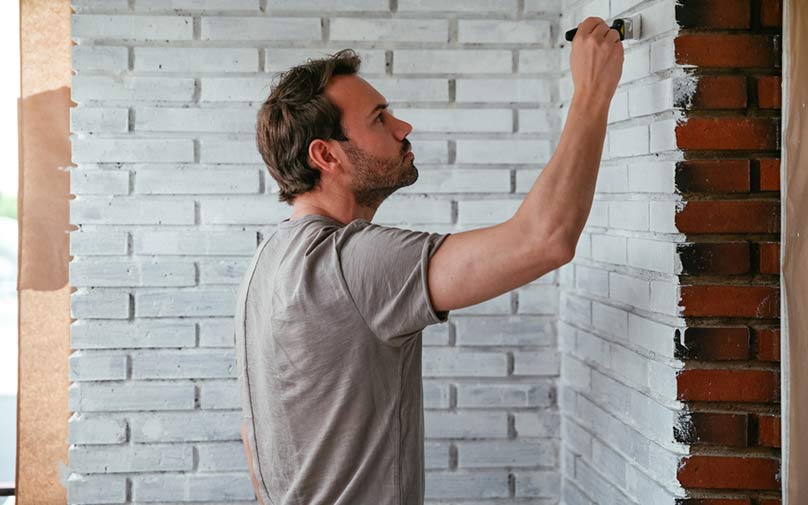 Man painting walls refreshing his home