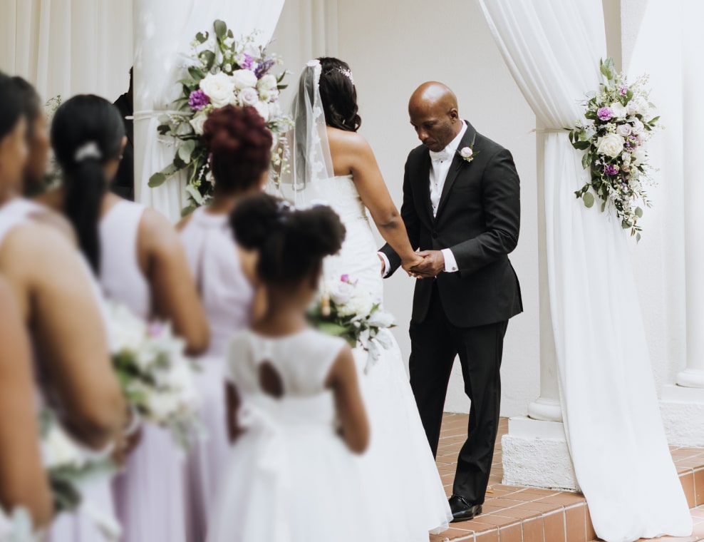 Couple standing at altar with bridal party watching