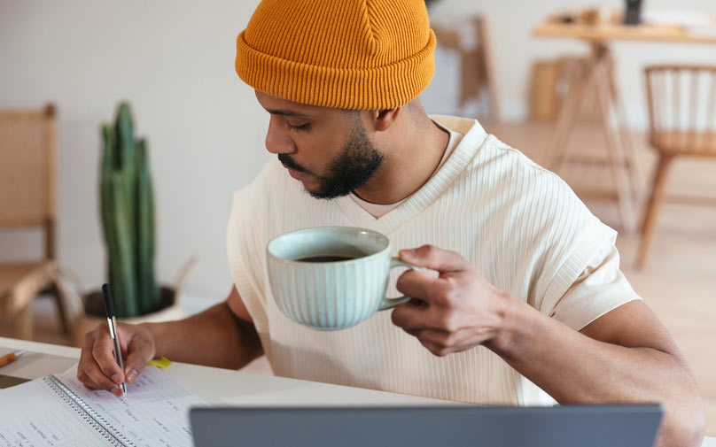 Man drinking coffee and budgeting his money.