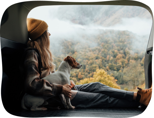 Women with dog looking out back of vehicle