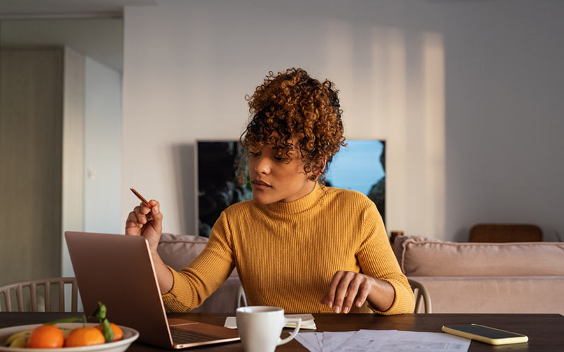 Woman calculating finances while sitting at table