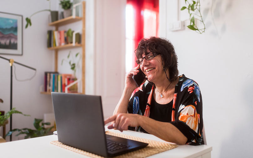 Woman talking to customer service while looking at computer