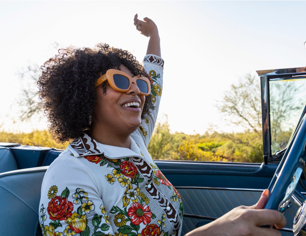 a happy and care-free woman driving in her car