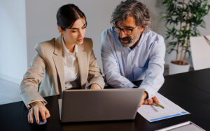 Man and woman in professional clothes building money mindset using computer