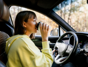 Woman in car drinking coffee