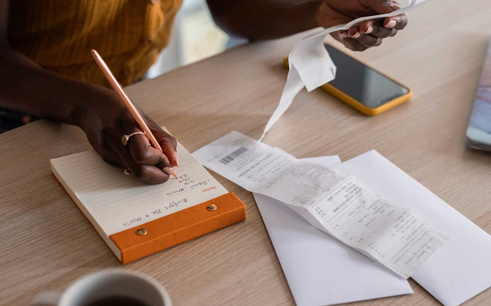 Close up of woman writing down a monthly budget