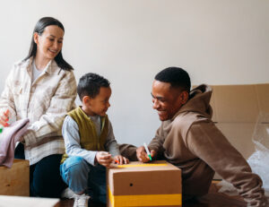 Family unpacking moving boxes together in new home