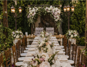 Elegant outdoor wedding reception table with white flowers and candlelit lanterns