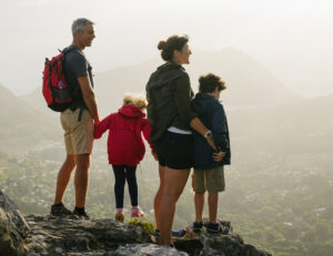 Family of four hiking together enjoying mountain vista during outdoor adventure