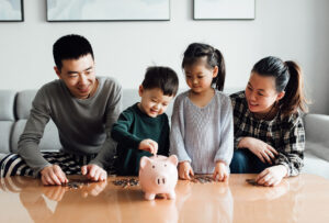 Family putting money into a piggy bank