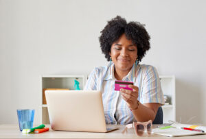 Woman on laptop looking at credit card
